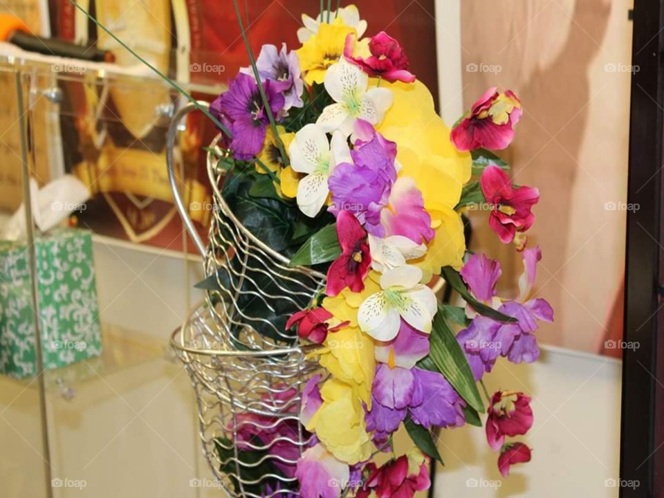A multicolored floral arrangement displaying vibrant and lively colors such as: purple, yellow, white, red, and green