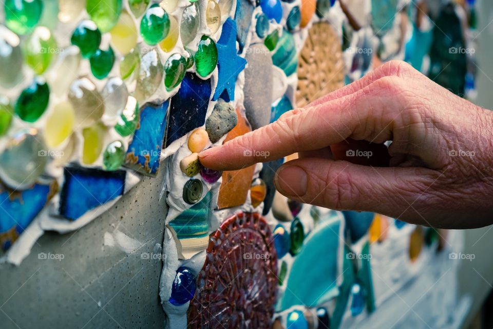 Hand putting mosaic piece in place