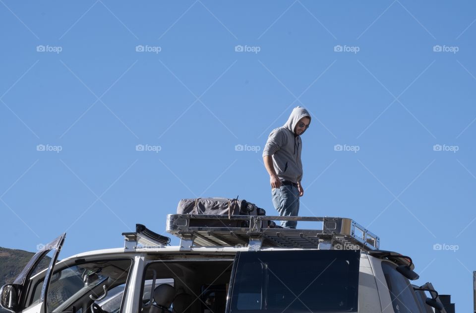 Traveler on roof of car to keep package