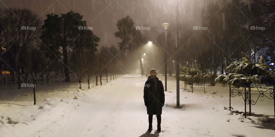 one girl in an empty park on a winter evening in the city of Kiev