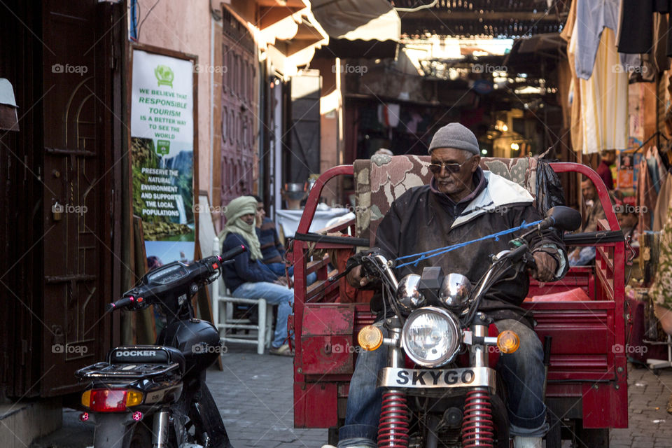 African man wearing sunglasses on a motorbike in the street