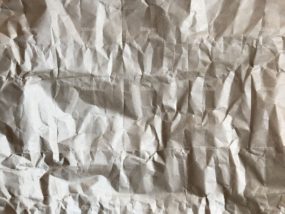 full frame of light brown crumpled paper looks like rock