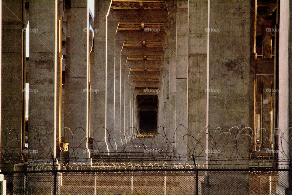 Barb wired fence and concrete pillars make up this highway city down below.