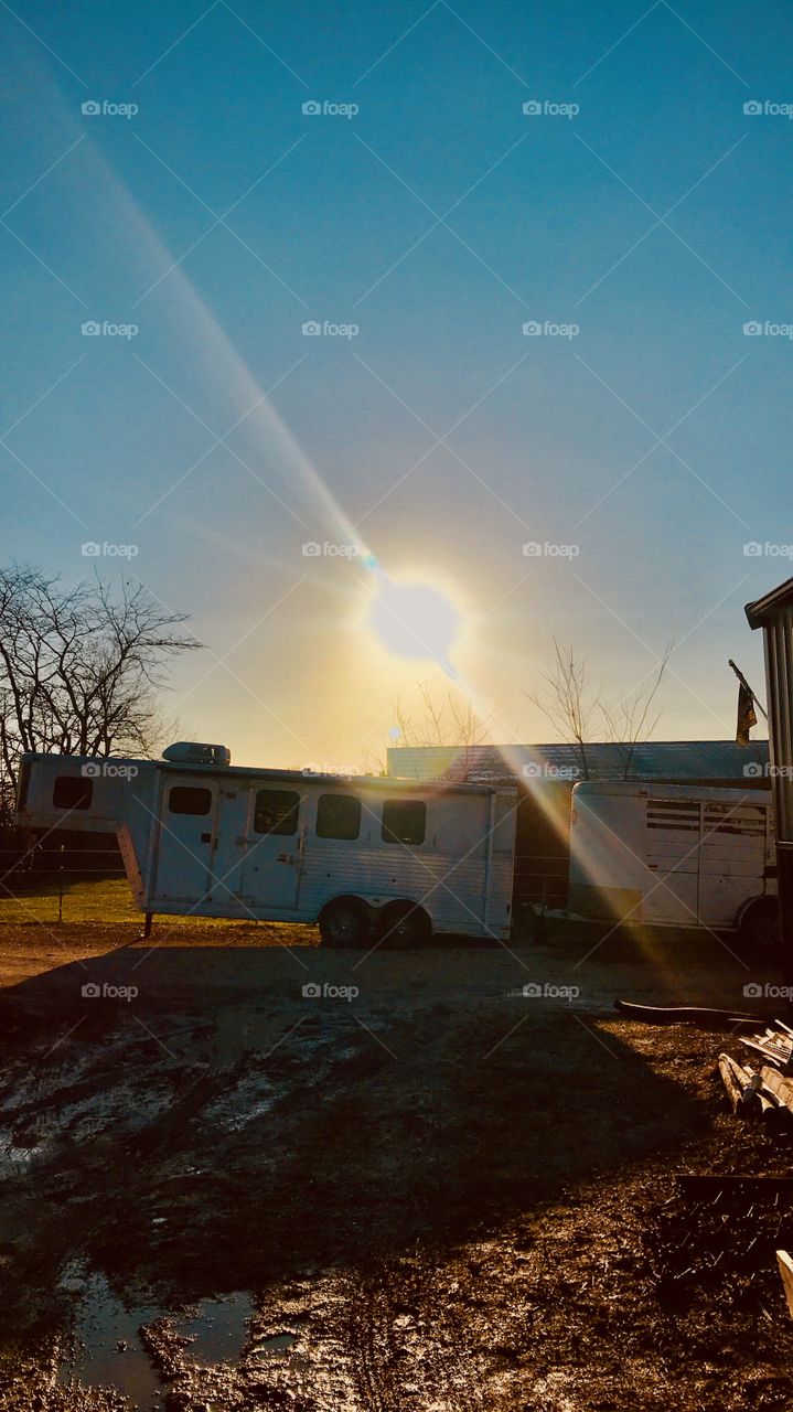 Sun dropping behind a trailer 