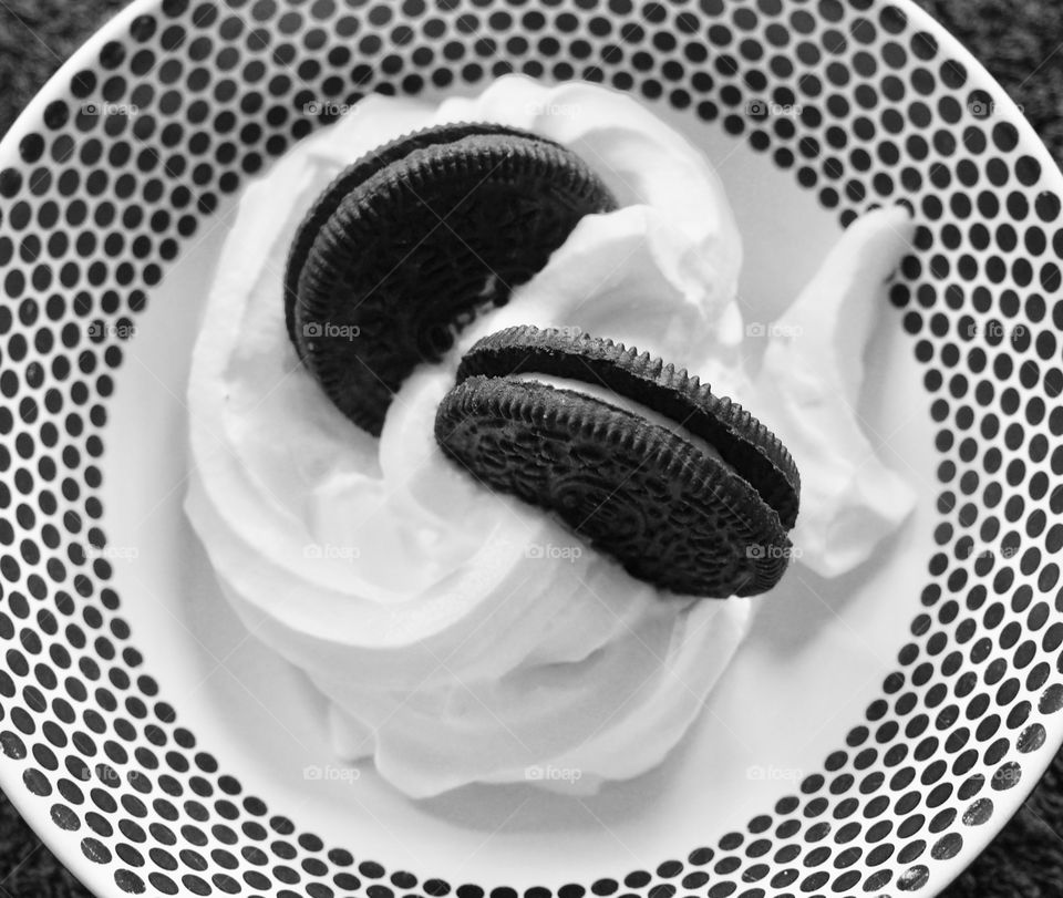 Oreo cookies with whipped in a black and white dotted bowl.