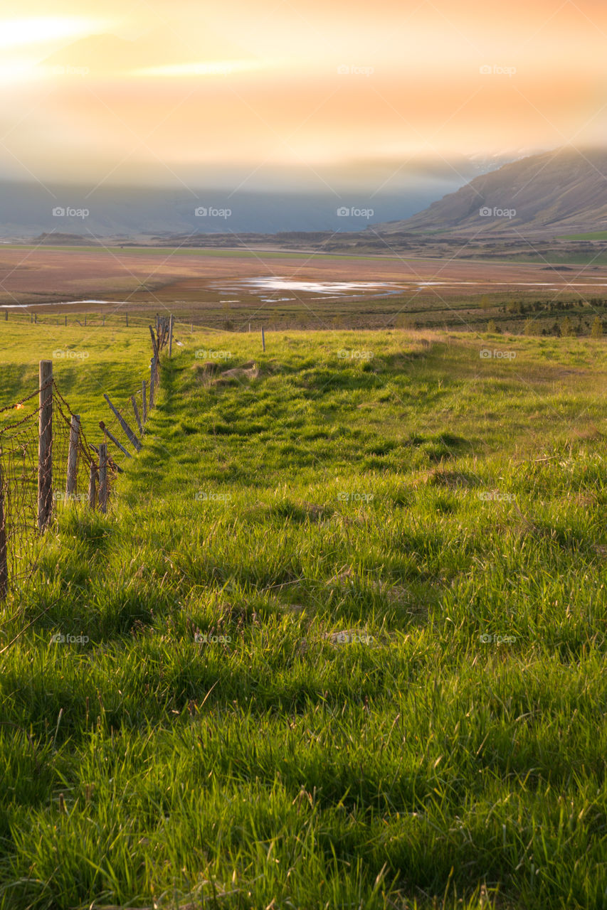 Fence in a pasture at sunset 