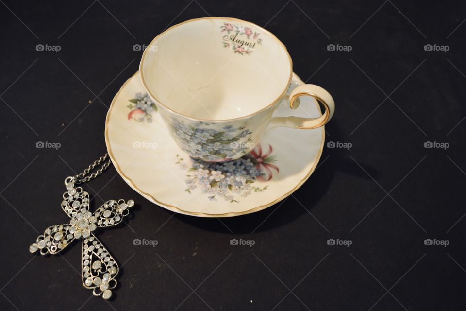 Antique saucer and tea cup with a cross