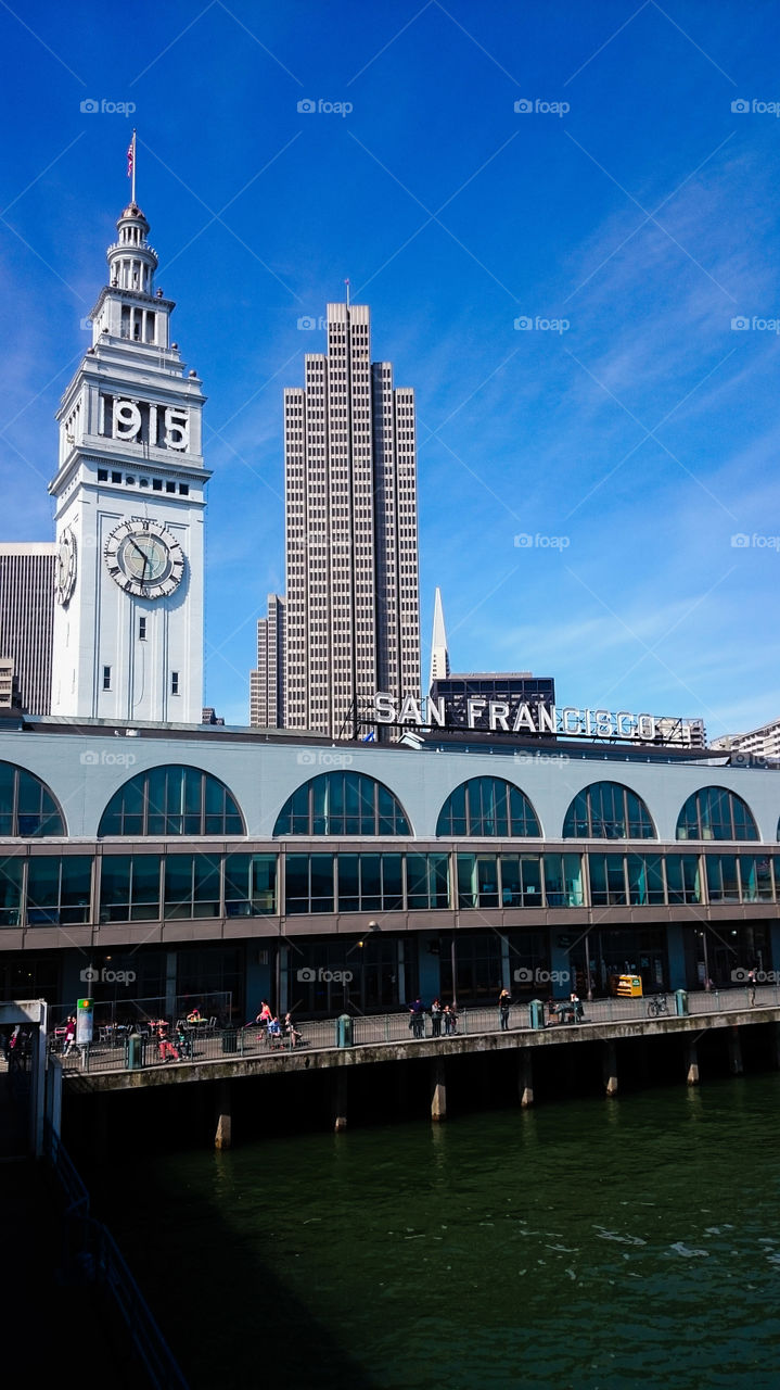 San Francisco Ferry Building. San Francisco's Ferry Building is an architectural landmark, see here with the 1915 World's Fair numbers, marking the 100th anniversary of the fair. Embarcadero Center towers in the background.