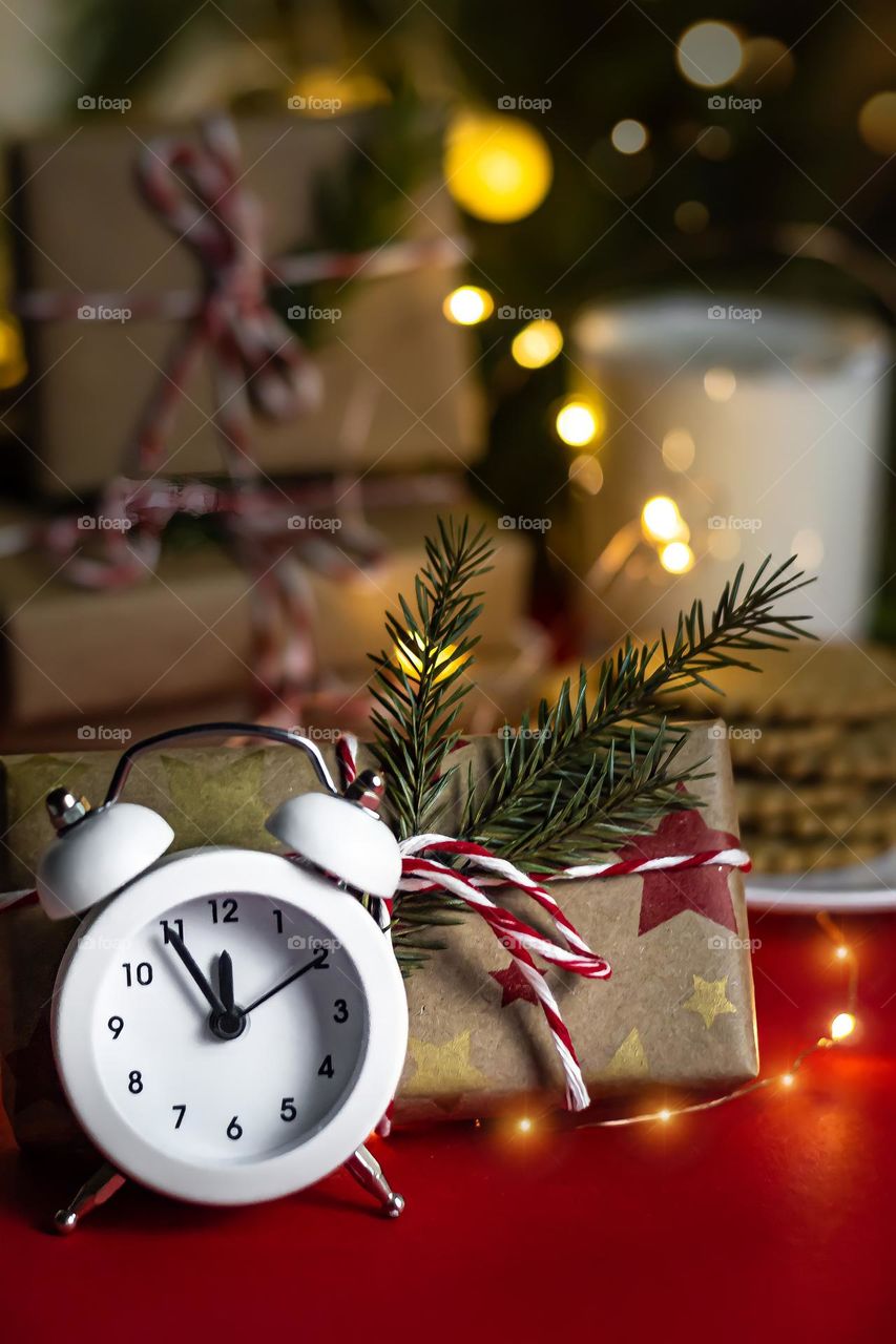 New Year's food composition on a red background, milk cookies for Santa and craft gifts and watches