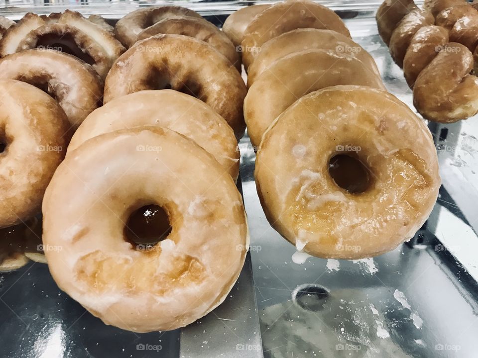 Delicious golden glazed donuts on display 