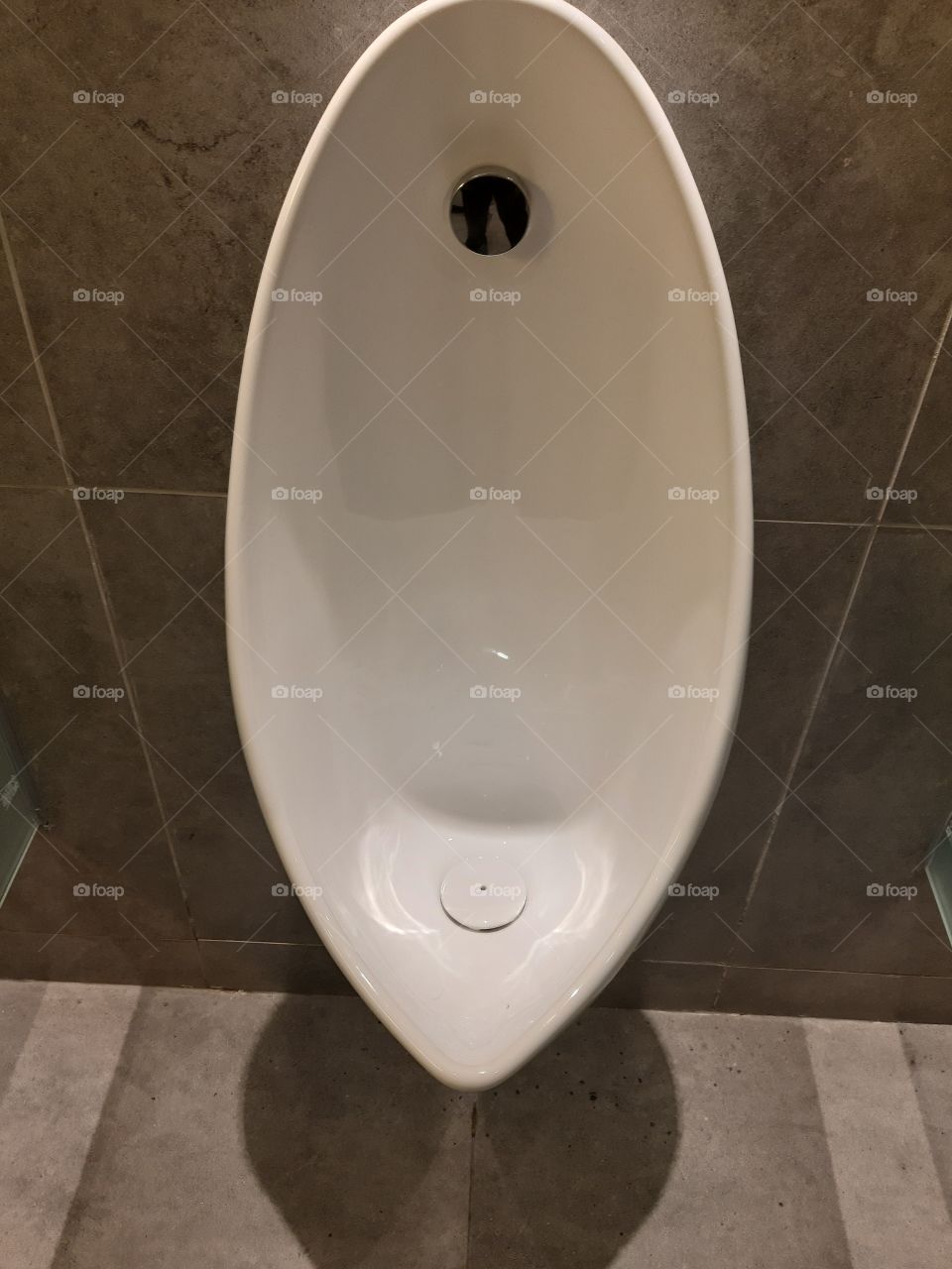 A standing white urinal in men toilet