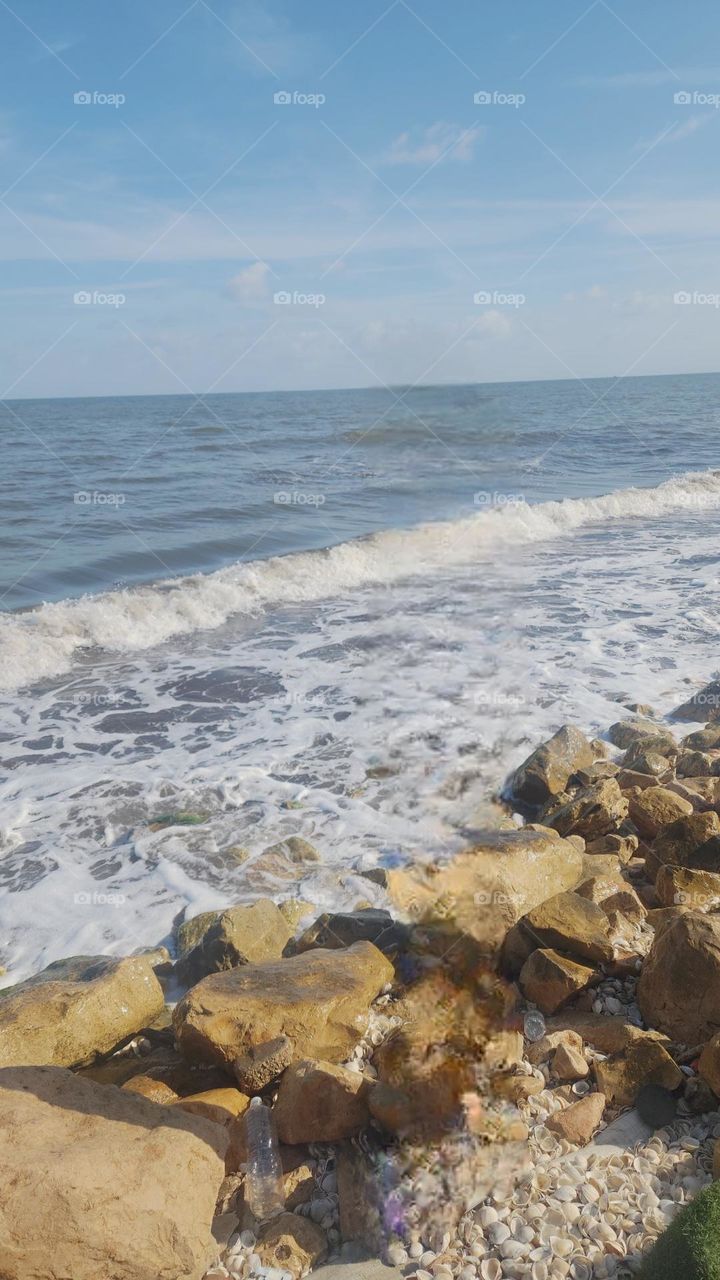 seaside scene where the waves gently meet the rocky shore.