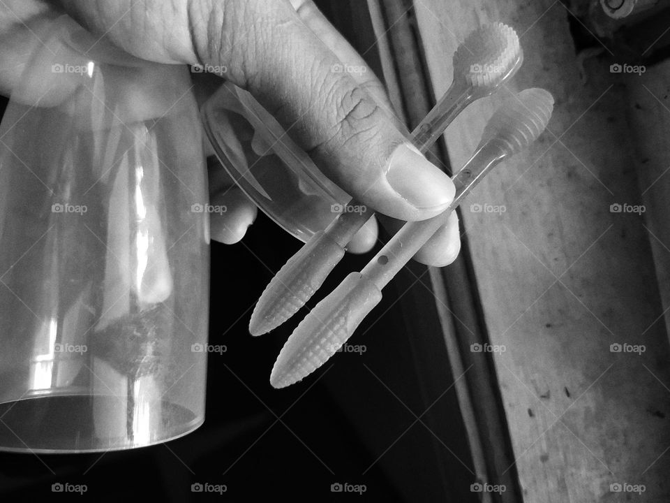holding a brush made of silicone to clean the baby's gums and tongue