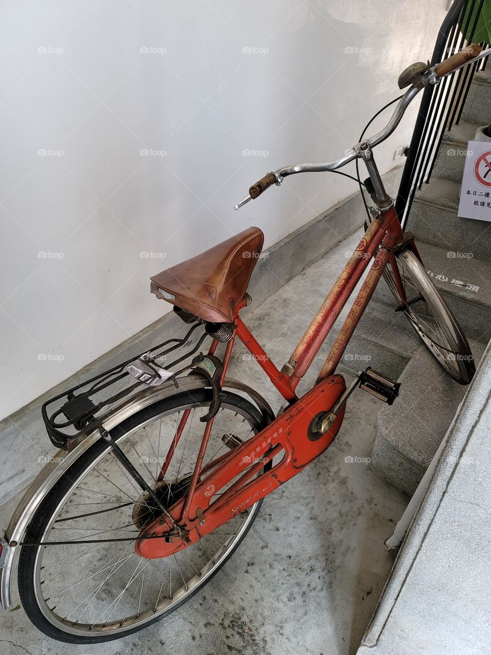 Red worn out bicycle in historic site