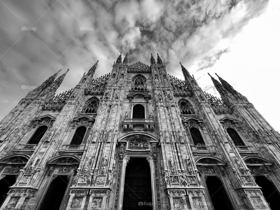 Monochrome shot of Milano Cathedral. View of the facade under the winter clouds. 