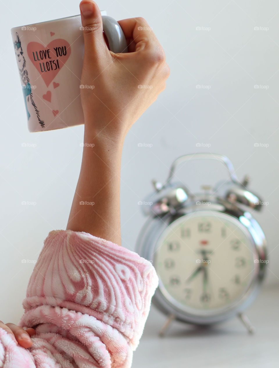 Lady's hand is holding a cup with a morning coffee