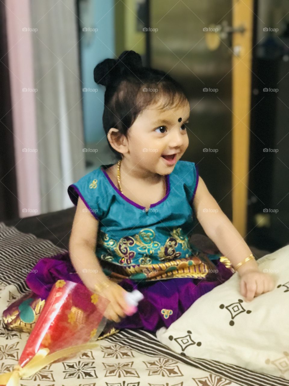 Little baby girl cute smile and wearing  indian traditional dress and bindi at her forehead.