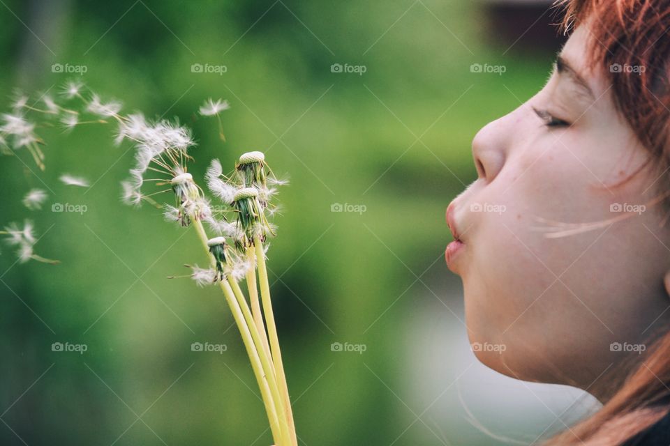 Girl blowing dandelion seeds