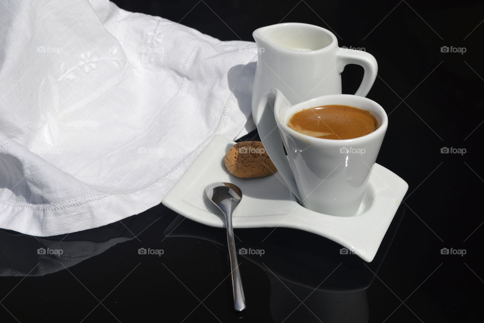 Cup of tea and milk with cookies on black background