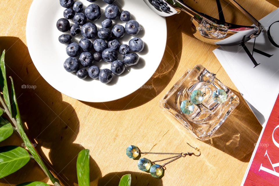 Fresh, appetizing blueberries on a white plate with holiday and summer items.