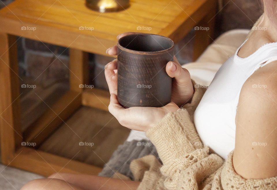 woman holding mug of hot drink