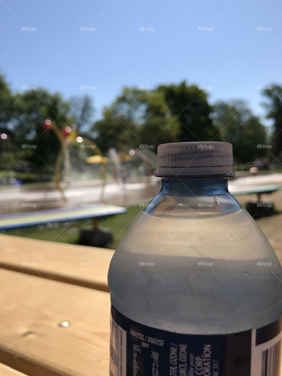 Closeup of a water bottle with water park in the background