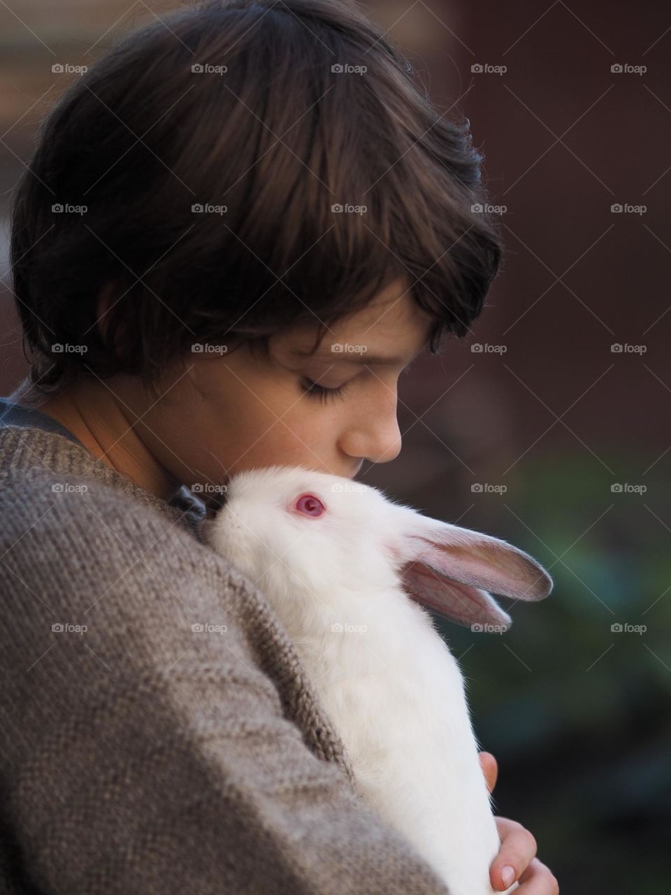Portrait of cute little boy with white fluffy rabbit 