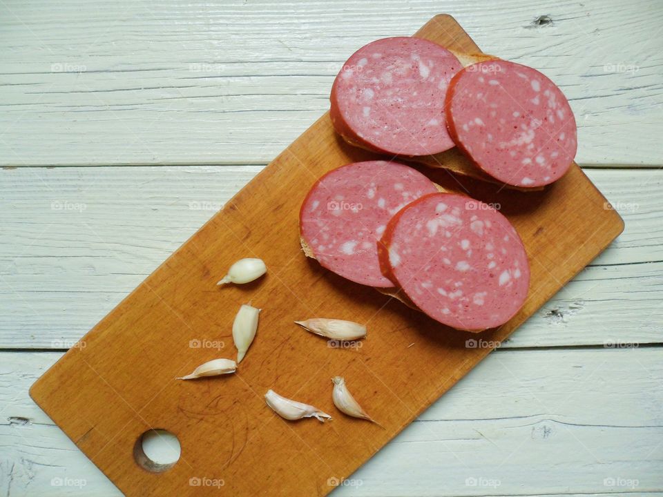 sandwiches with sausage and garlic on a cutting board