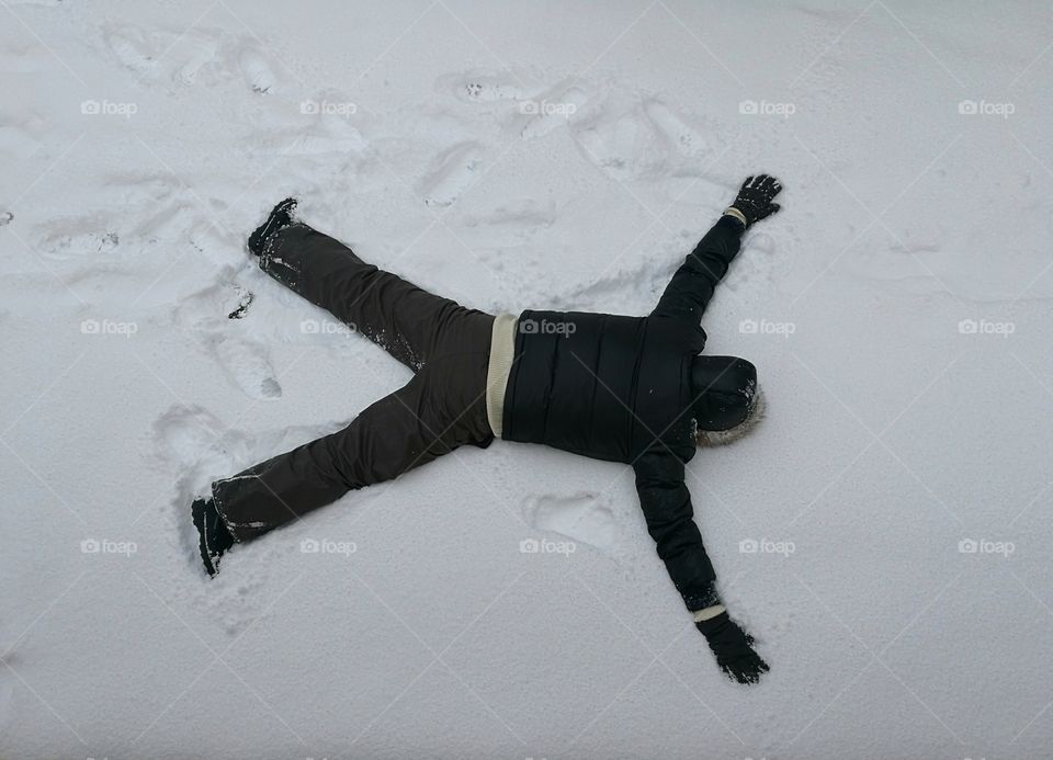 Man lying on his stomach on the snow