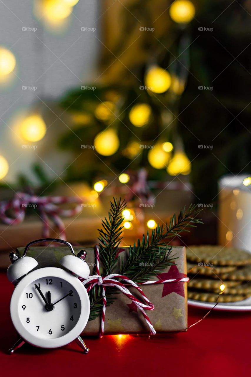 New Year's food composition on a red background, milk cookies for Santa and craft gifts and watches