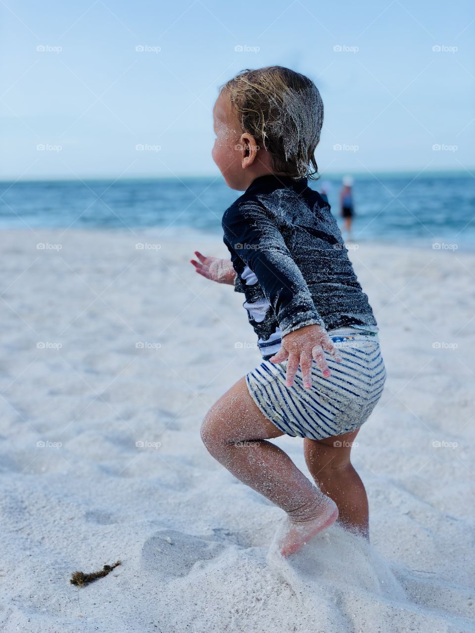 Little boy sprinting down the beach 