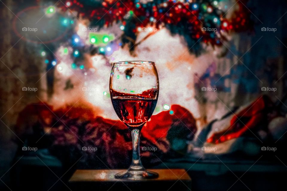 glass of a wine on the box of a present under the Christmas tree