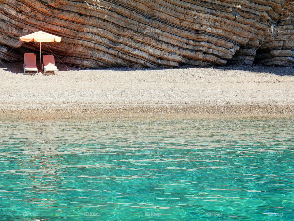 Lounge chair and beach umbrella on beach