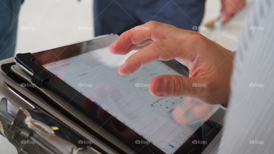 Man working with plans on ipad. Architect discussing architectural plans using his mobile tablet. Drawings review and proposals 