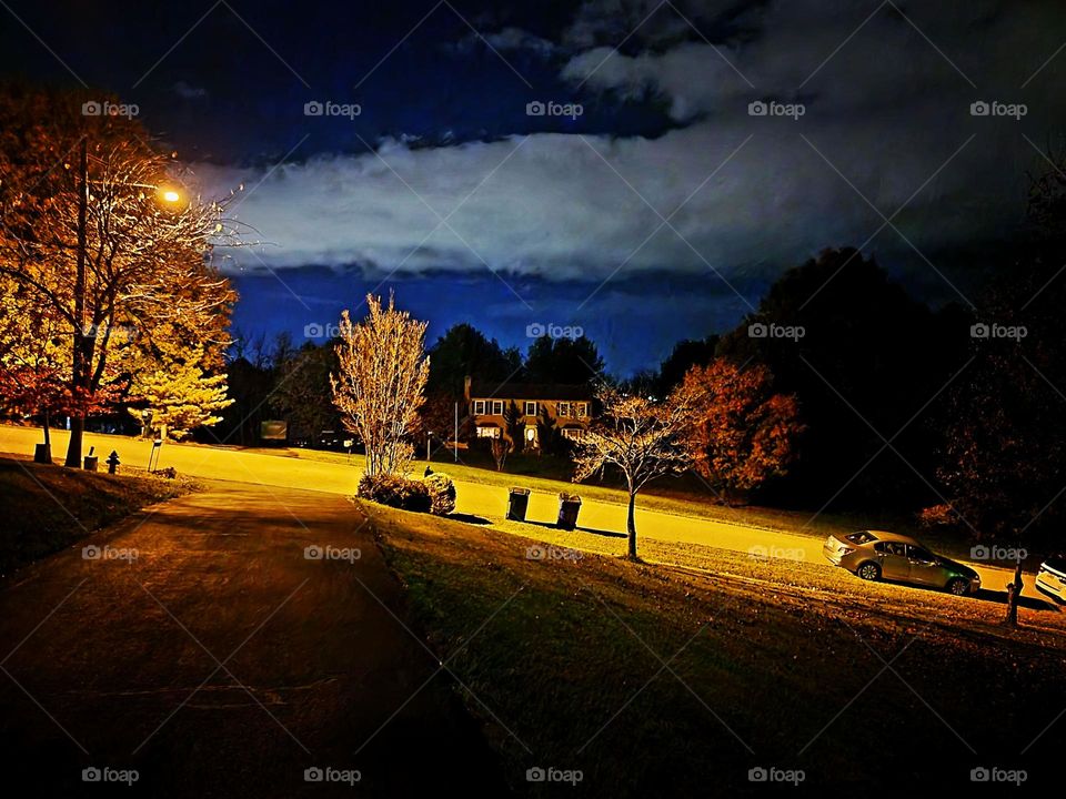 night photo of house with streetlight and clouds