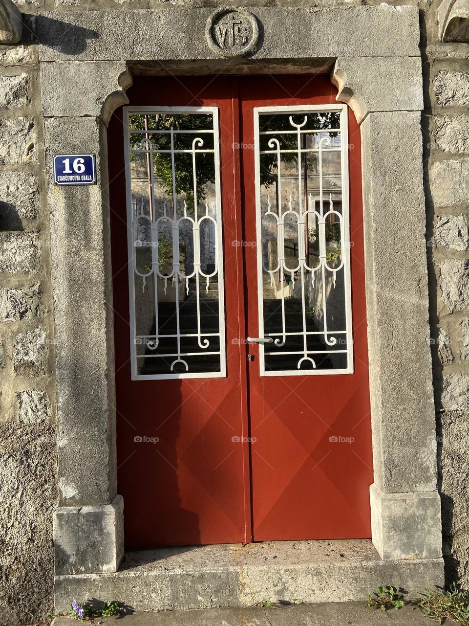 The red gate against stone wall.