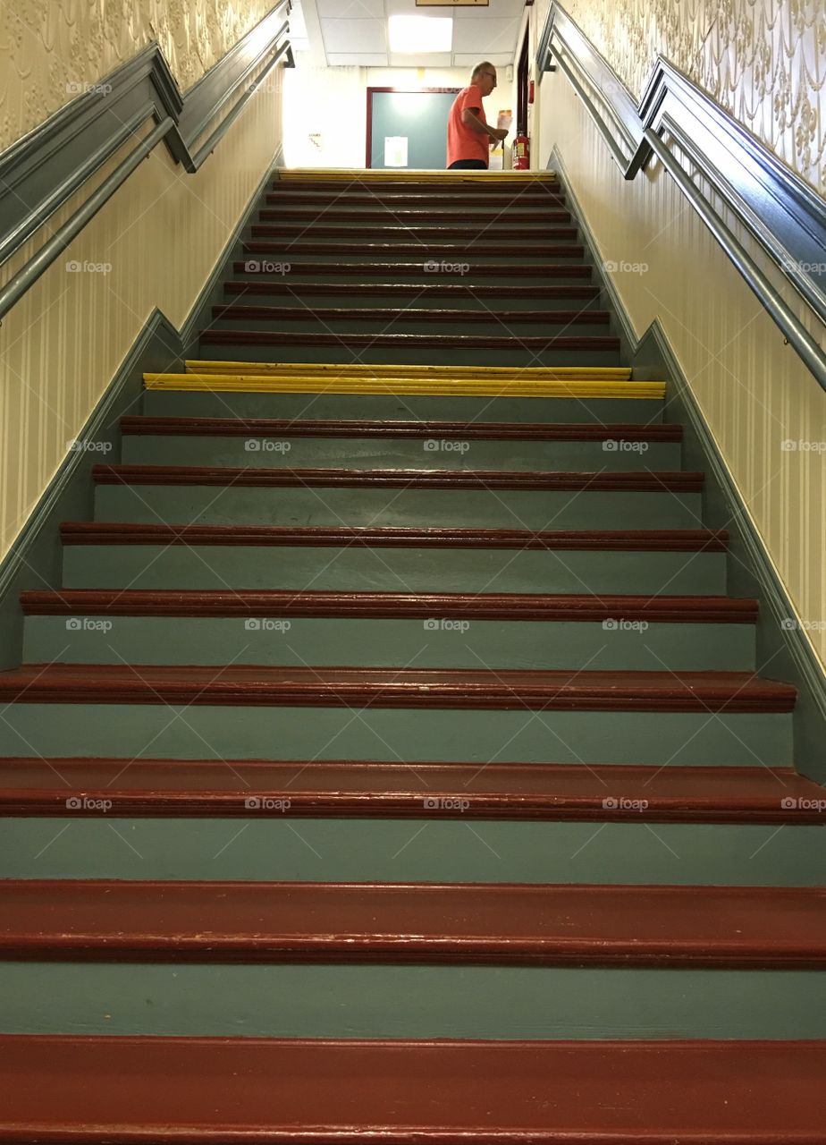 Man at top of government town building stairway.