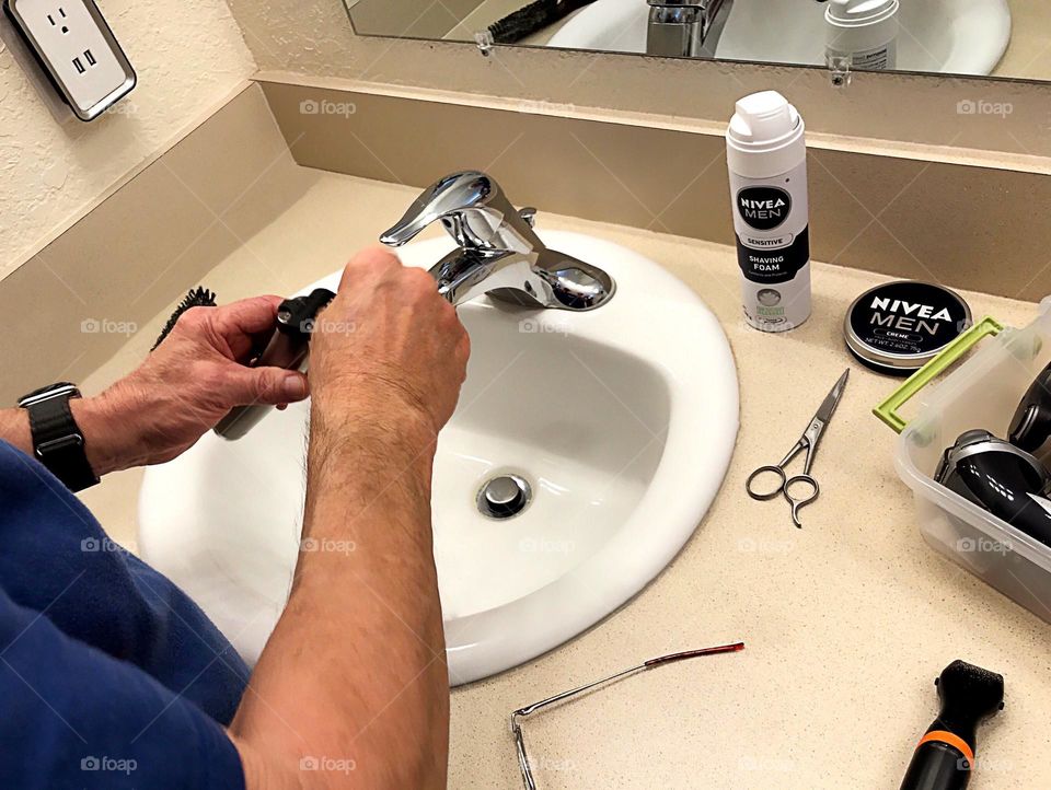 Man preparing his clippers for shaving.