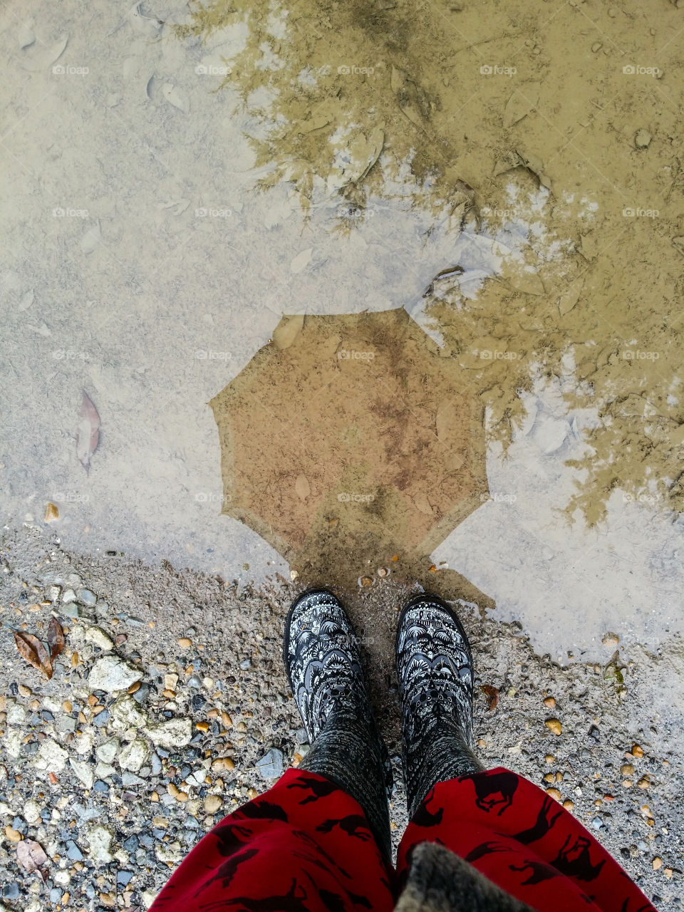 Low section of a person standing near puddle