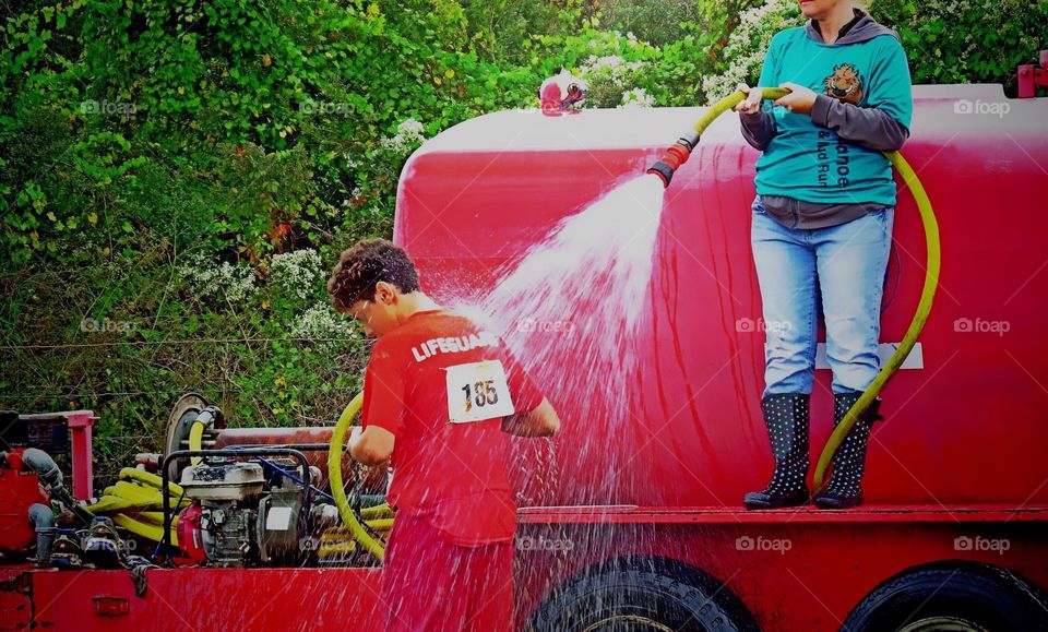 Cooling off in a fire hose after a road race.