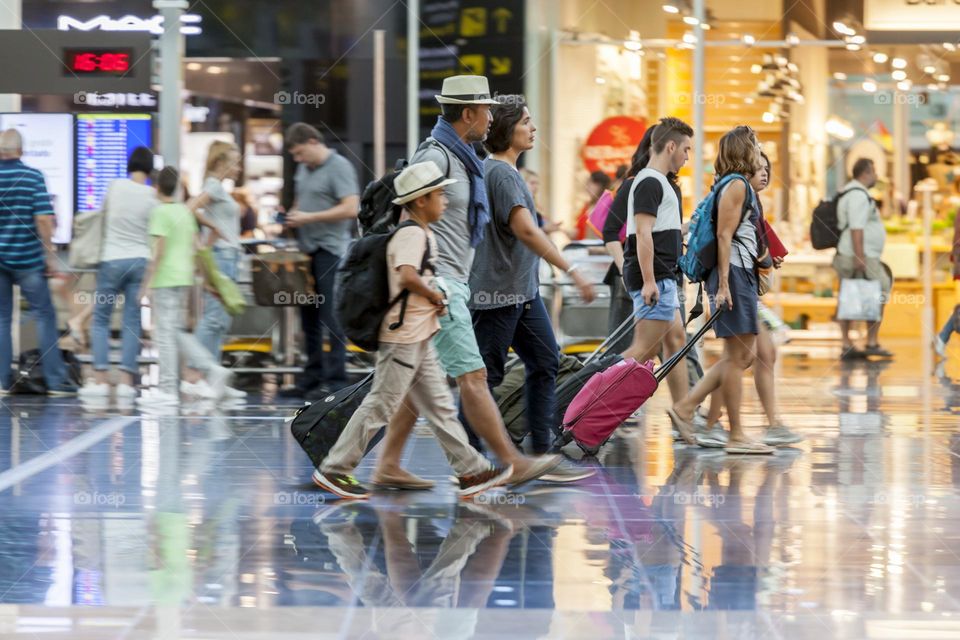 Family walking towards departure gates at the airport