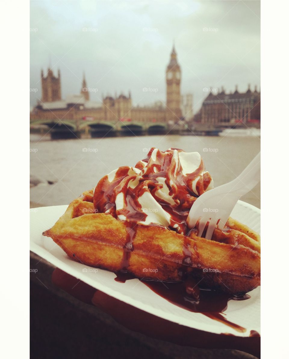 Eating a waffle with a lot of cream and chocolate sauce in front of the Big Ben and Westminster in London