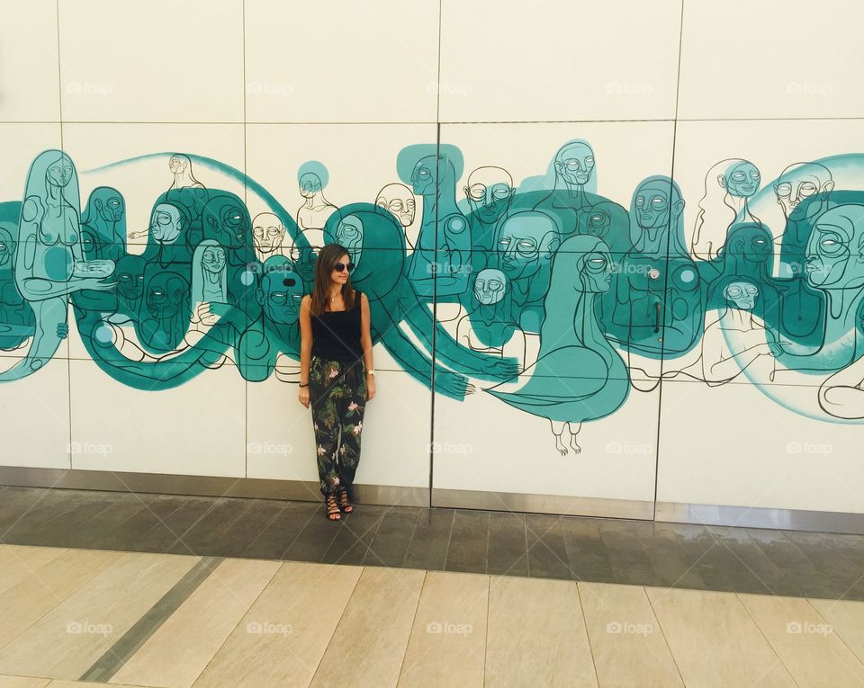 Woman standing near printed wall