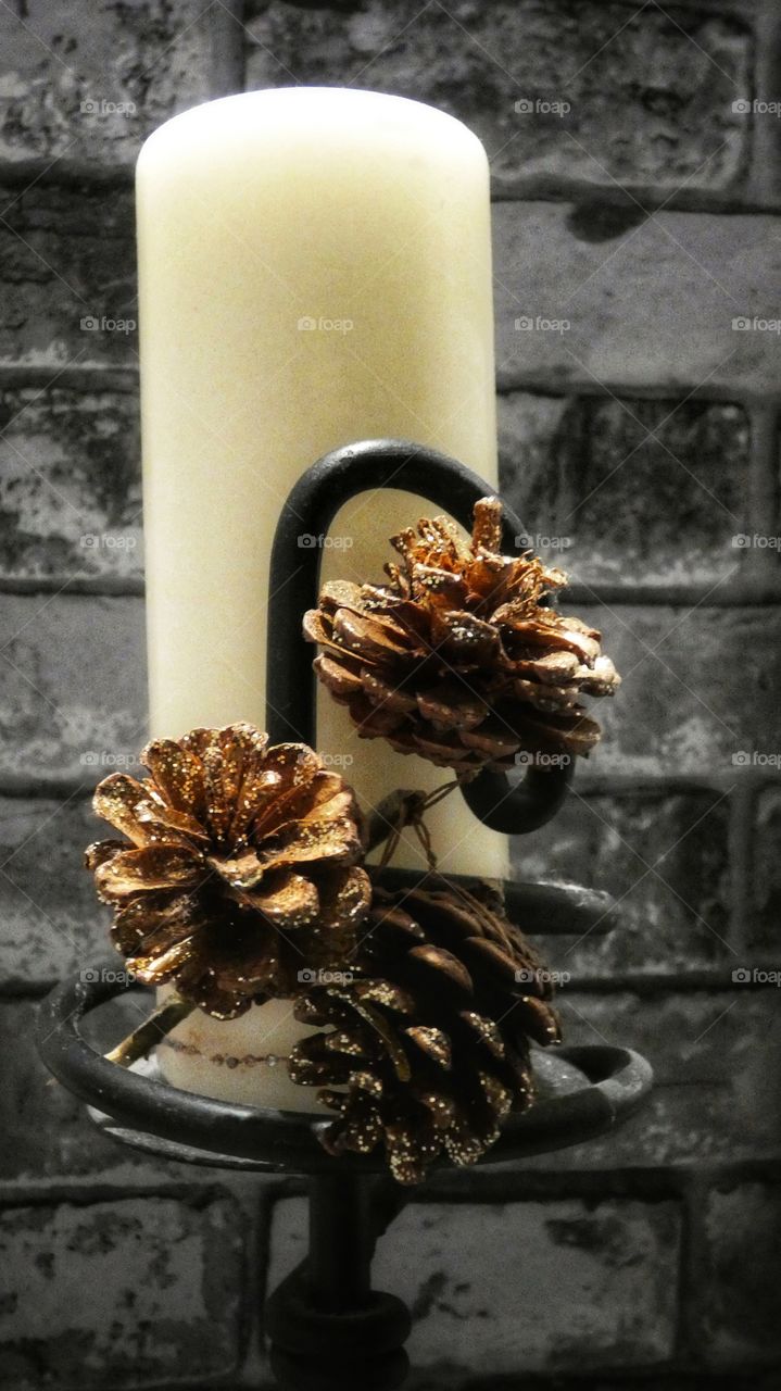 Candle with ace corns against brick wall