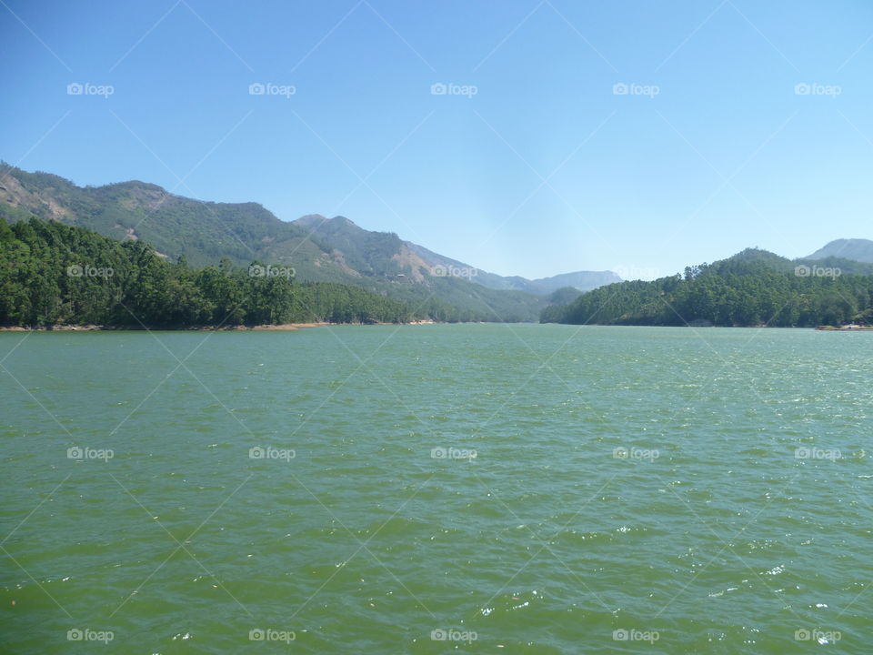 Back water of dam surrounding mountains