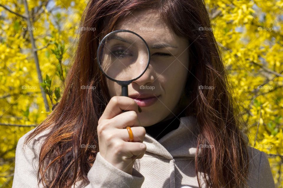Woman holds a magnifying glass