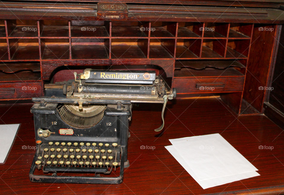 Antique Remington typewriter sitting on antique wooden desk