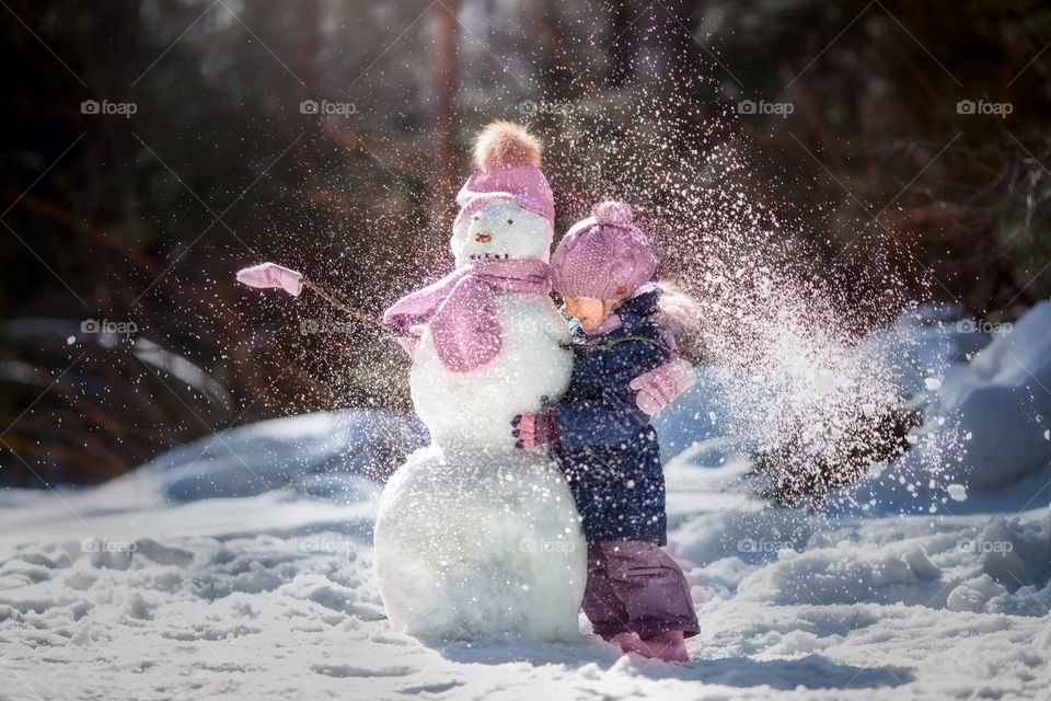 Little girl with snowman