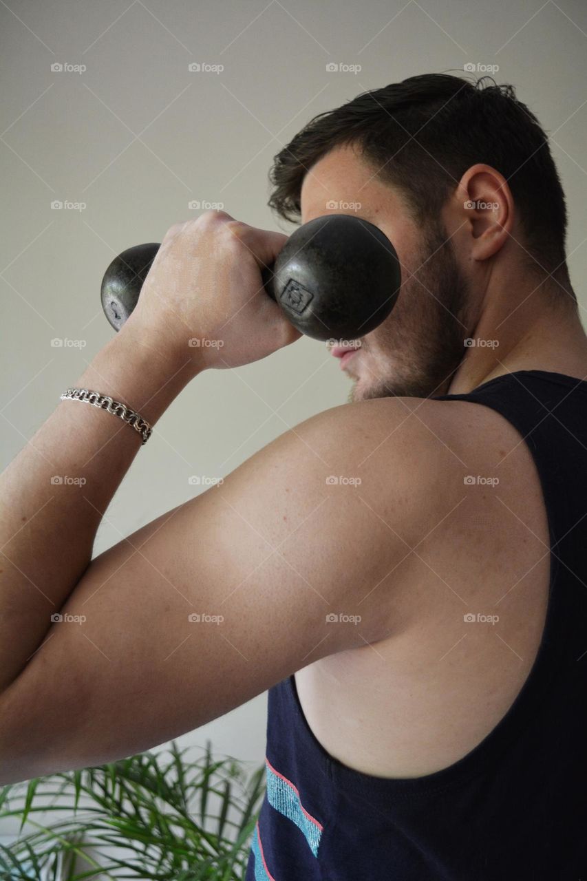 men training indoor, dumbbell in the hand