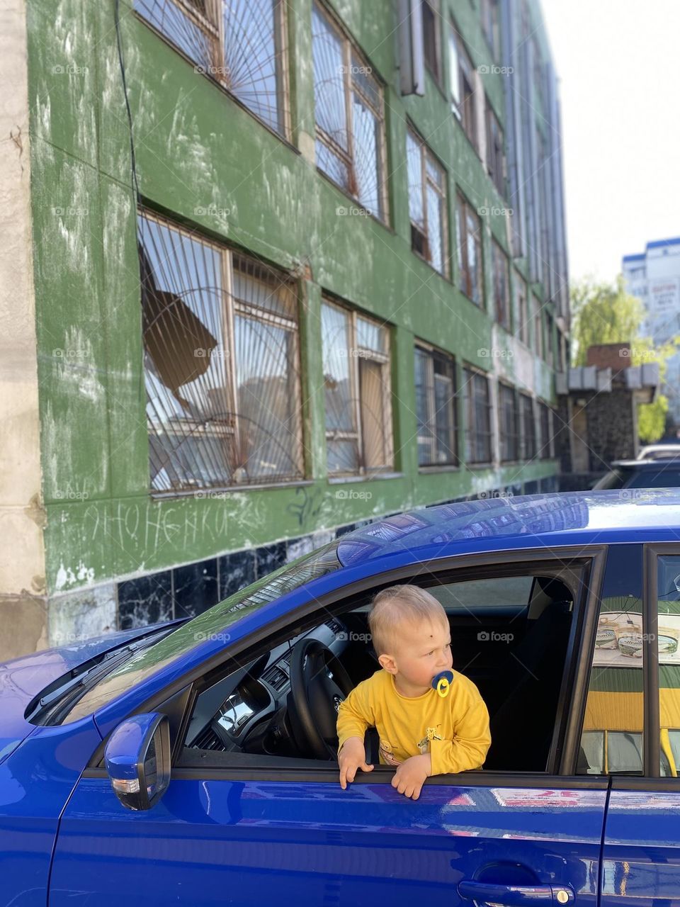 Boy in car near abandoned building